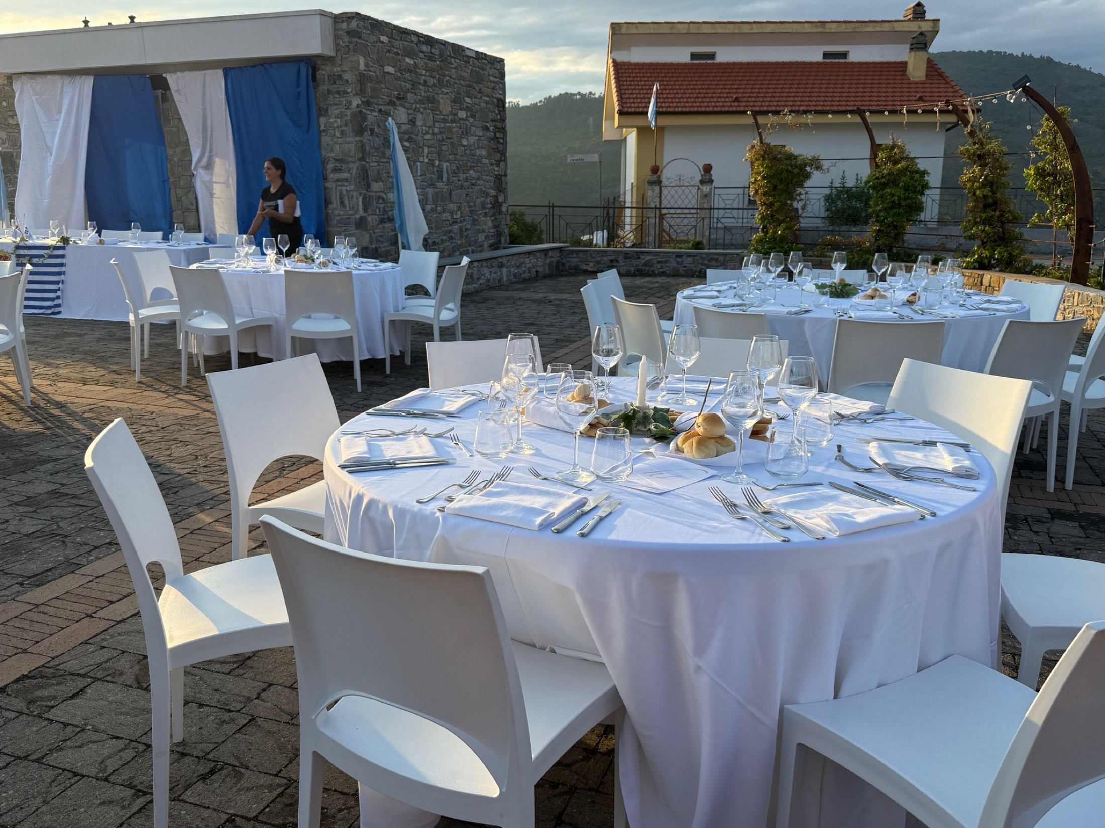 Dinner tables set on a terrace at sunset